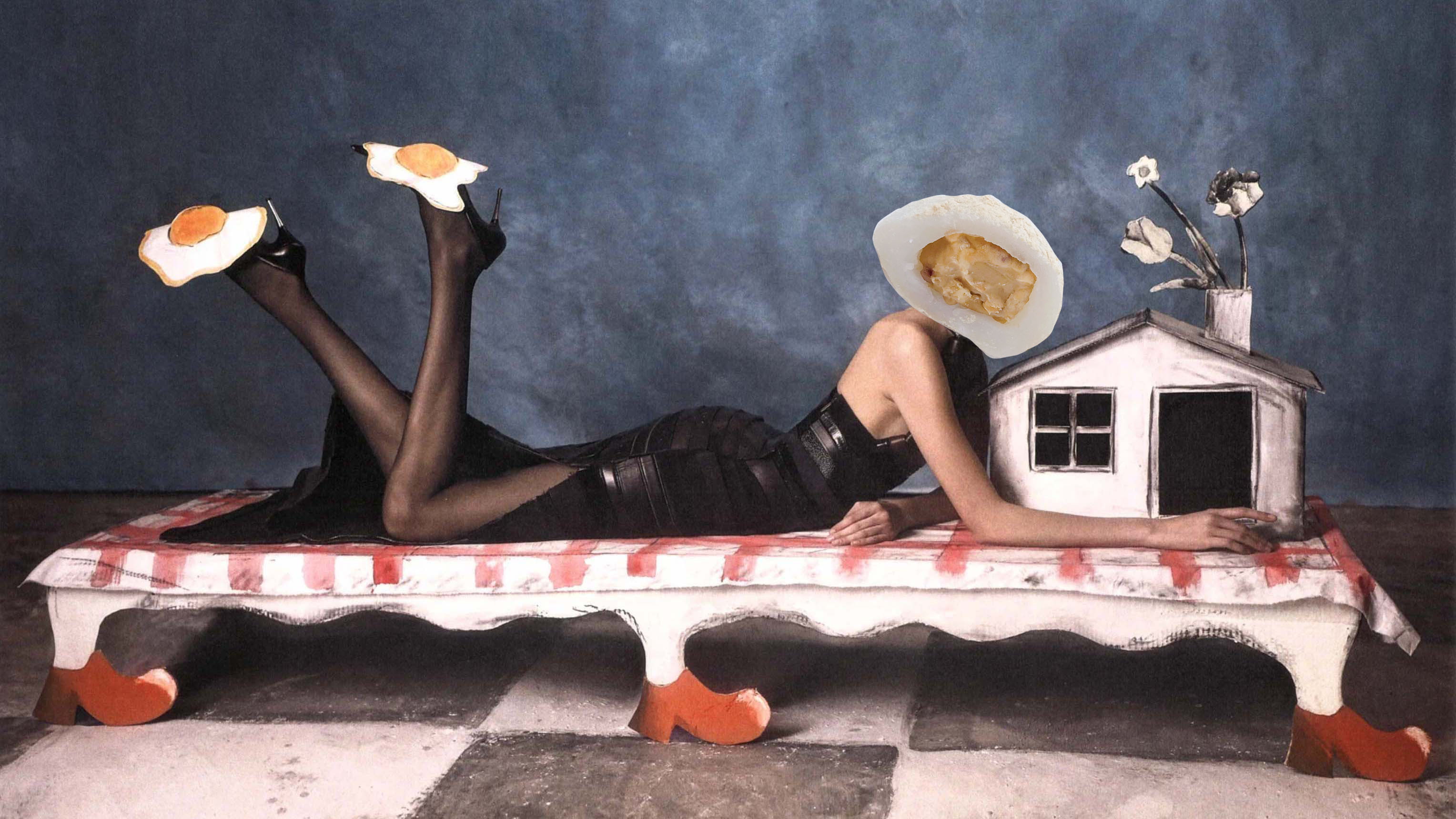 woman lying on table in all black dress and heels with faux egg on heels